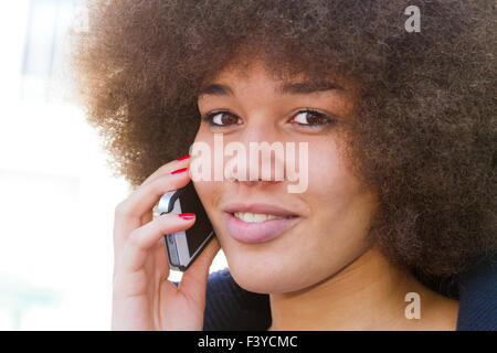 African American woman with a frizzy afro hairstyle with smart phone Stock Photo