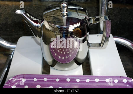 https://l450v.alamy.com/450v/f3ye67/a-purple-tea-tray-reflected-in-a-shiny-metal-teapot-at-a-welsh-seaside-f3ye67.jpg