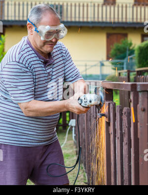 In the picture a older man at work using a sander. Stock Photo
