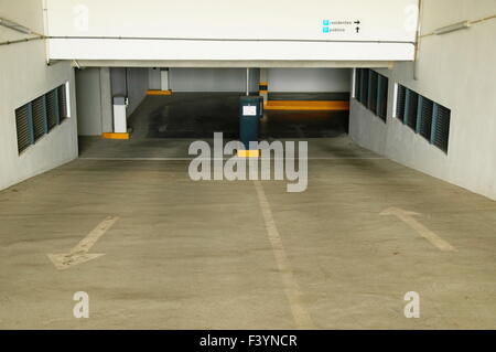 Public garage entrance framed by white walls with windows Stock Photo