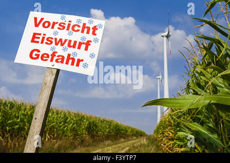 Danger sign in front of wind turbines Stock Photo