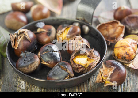 Roasted chestnut in frying pan on black stone background Stock Photo - Alamy