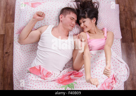 Young couple waking up in bed and sipped Stock Photo