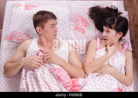 Unfamiliar man and woman wake up in bed Stock Photo