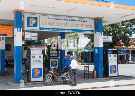 Petrolimex petrol station in Hoi An Vietnam, man is helped by station attendant to refuel his Scooter motorcycle,Vietnam Stock Photo