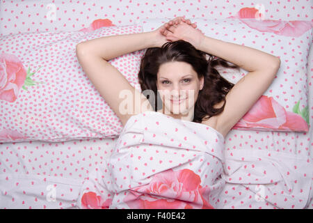 Joyful beautiful girl has woken up in bed Stock Photo