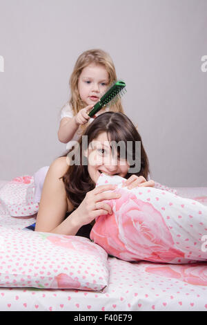 Year old daughter combed hair mom Stock Photo