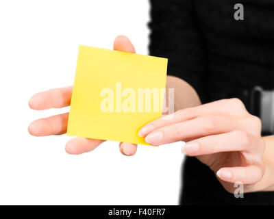 Beautiful woman hands with blurred silhouette holding blank yellow memo stick. Isolated on white with clipping path Stock Photo