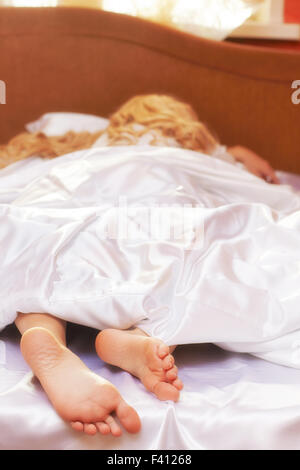 Blonde young woman in the bed Stock Photo