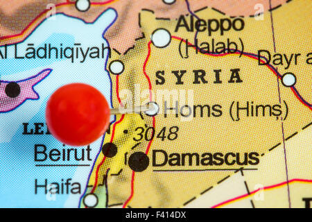 Close-up of a red pushpin in a map of Homs, Syria. Stock Photo