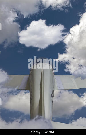 Small private plane in the sky flying through clouds. Stock Photo
