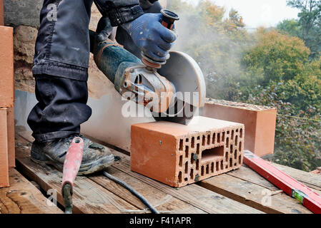 Construction worker using masonry saw to cut concrete blocks to build a new wall Stock Photo