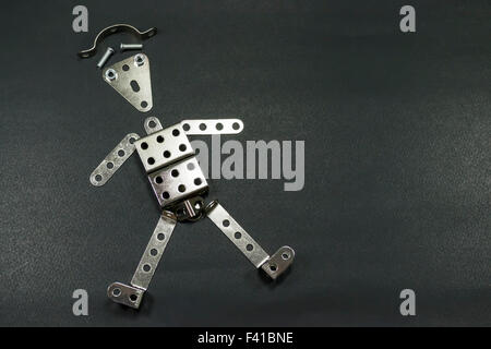 Perforated metallic plates arranged in the form of a funny robot or tin man , against a black background Stock Photo