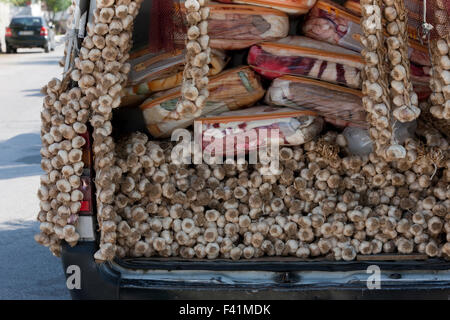 Bunch of dried hanging garlic clove plaits for sale on a gypsy peddler's van. Stock Photo