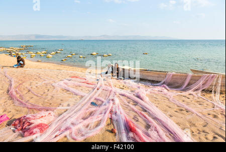 Local fisherman mending his fishing nets on the beach, Kaya Mawa, Likoma Island, Lake Malawi, Malawi, south-east Africa Stock Photo