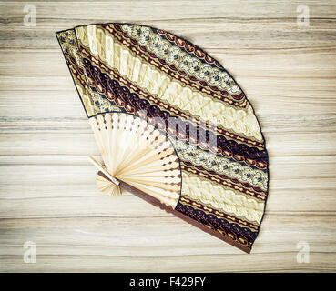 Traditional eastern fan on the wooden background. Stock Photo