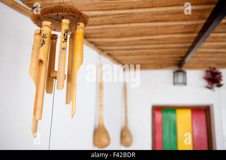 Hanging bamboo wind chimes and reggae color wooden door at the bottom Stock Photo