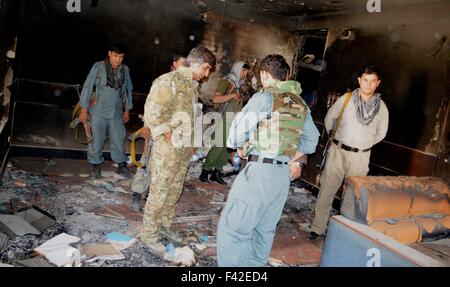 Kunduz, Afghanistan. 14th Oct, 2015. Policemen stand in a destroyed room of a government building after Taliban fighters burnt it down in Kunduz city, capital of northern Kunduz province, Afghanistan, Oct. 14, 2015. The Afghan security forces evicted Taliban militants from the northern Kunduz city on Oct. 13 and begun returning normalcy there after 11 days of fierce fighting and cleanup operations, provincial police chief Mohammad Qasim Jangal Bagh said. Credit:  Omid/Xinhua/Alamy Live News Stock Photo
