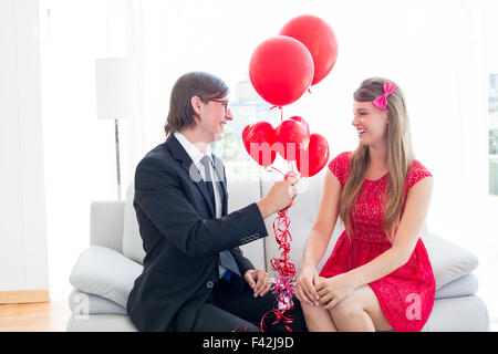 Cute geeky couple with red balloons Stock Photo - Alamy
