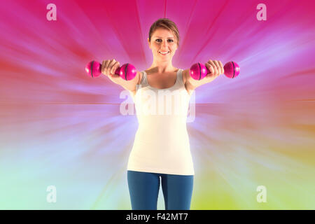 Composite image of woman holding weights Stock Photo