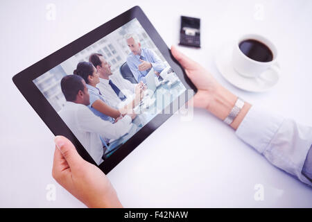 Composite image of man using tablet pc Stock Photo