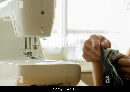 Woman using sewing machine, cropped Stock Photo