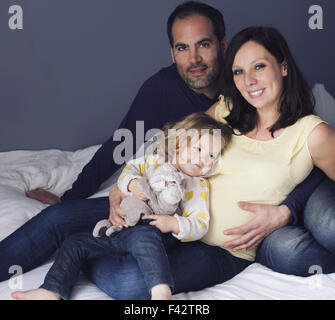 Parents and young daughter sitting together, portrait Stock Photo