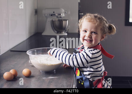 Little girl mixing batter, smiling, portrait Stock Photo