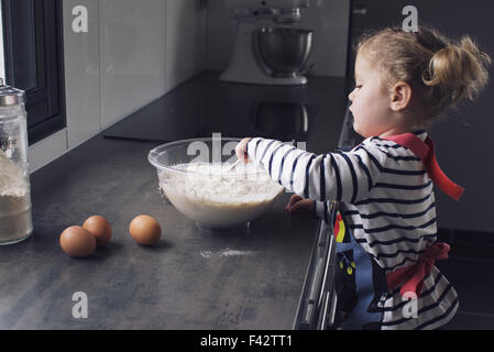 Little girl mixing batter Stock Photo