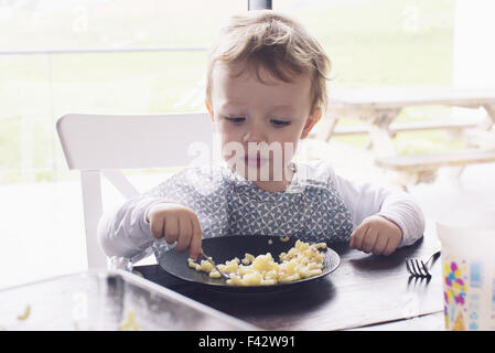 Little boy eating macaroni Stock Photo