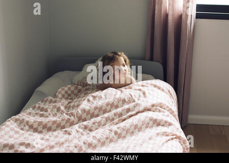 Little girl sitting in bed Stock Photo