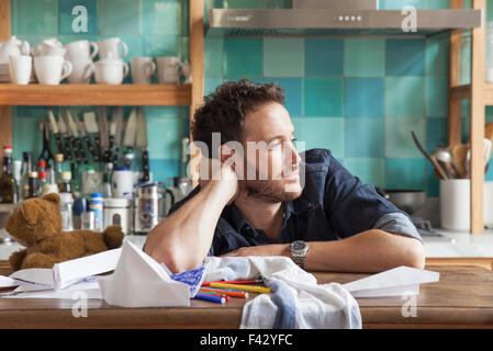 Man daydreaming in kitchen Stock Photo