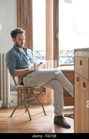 Man using smartphone at home Stock Photo