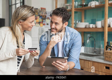 Couple using digital tablet to shop online at home Stock Photo