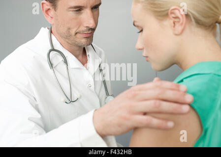 Doctor comforting upset patient Stock Photo
