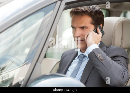 Businessman talking on cell phone in car Stock Photo