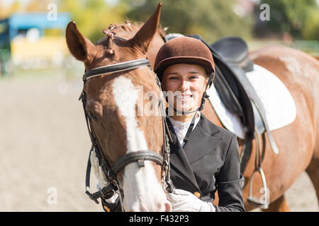 Young smiling rider girl with her horse Stock Photo
