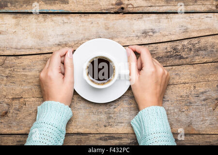 Woman holding cup of espresso on wooden table. Breakfast cafe menu background Stock Photo