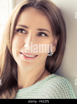 Toned image of attractive young woman relaxing and dreaming. Pretty smiling  caucasian girl