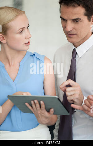 Business associates using digital tablet together Stock Photo