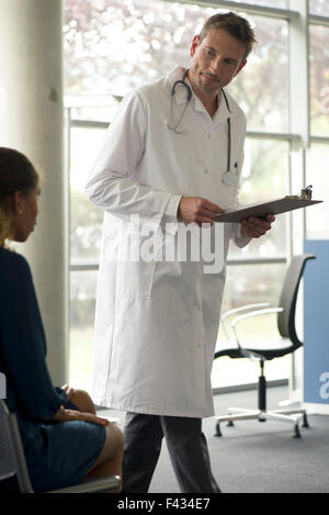 Doctor talking with patient in waiting room Stock Photo