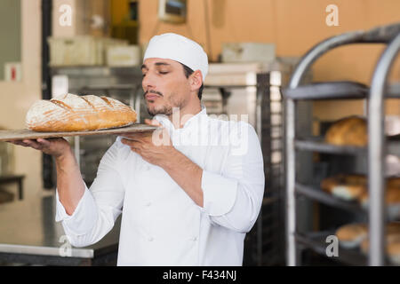Baker smelling a freshly baked loaf Stock Photo