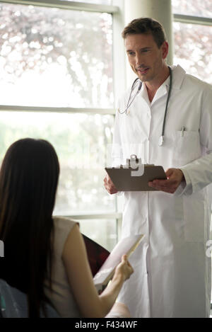 Doctor greeting patient in waiting room Stock Photo