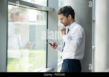 Man using cell phone with hands-free device Stock Photo