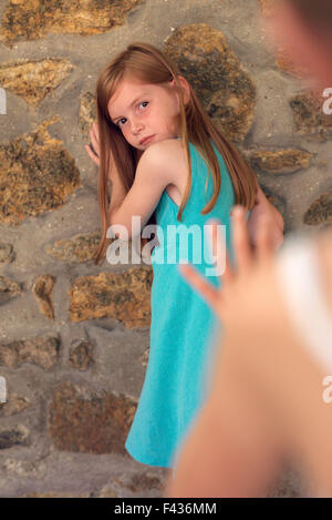 Girl leaning against wall during game of tag Stock Photo