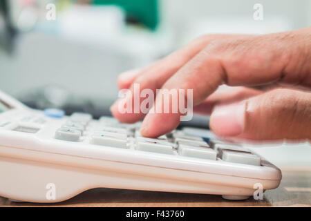 Calculator and a hand that was pressing on a calculator. Stock Photo