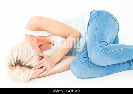 Sad blonde woman lying on the floor Stock Photo - Alamy
