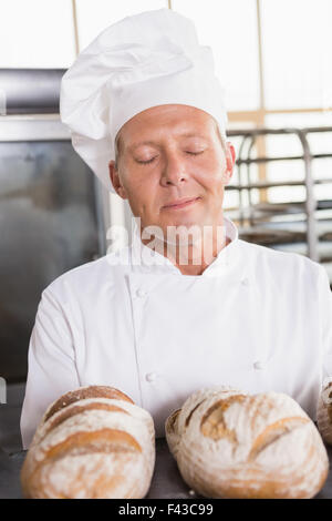 Baker smelling freshly baked breads Stock Photo