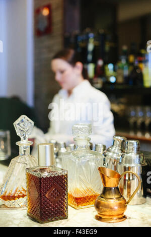 Young woman mixing a cocktail at a bar in a city restaurant. Stock Photo