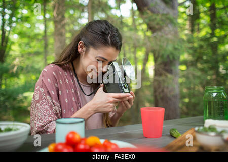 A woman using a vintage camera with separate metal flash unit. Stock Photo